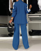 LA FINE FLEUR notched collar blazer with white sleeve stripes and matching wide-leg pants.