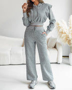 A cropped long sleeve hoodie with shoulder padding and matching wide-leg pants, both with thumbholes.