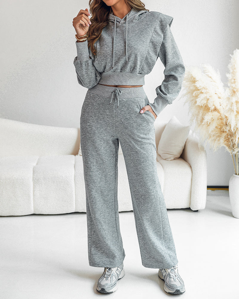 A cropped long sleeve hoodie with shoulder padding and matching wide-leg pants, both with thumbholes.