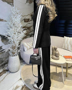 LA FINE FLEUR notched collar blazer with white stripes and matching wide-leg pants set.