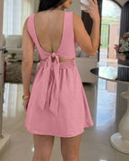 A light pink square neck thick strap textured romper with tie back skorts.