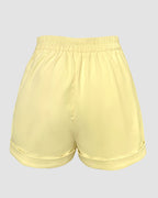 A light yellow V-neck sleeveless top with matching high-waisted shorts and rolled hems.