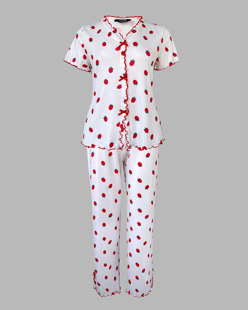 A strawberry print pajama set with stand collar tee, short sleeves, long pants, red ruffle trim.