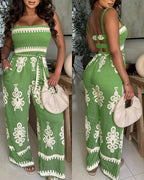 Green and white vintage floral jumpsuit with smocked bodice, strappy back, wide legs, tie belt.