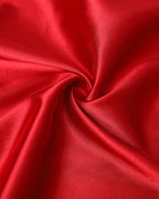 Red satin babydoll dress featuring lace and crisscross details, with a glossy sheen.