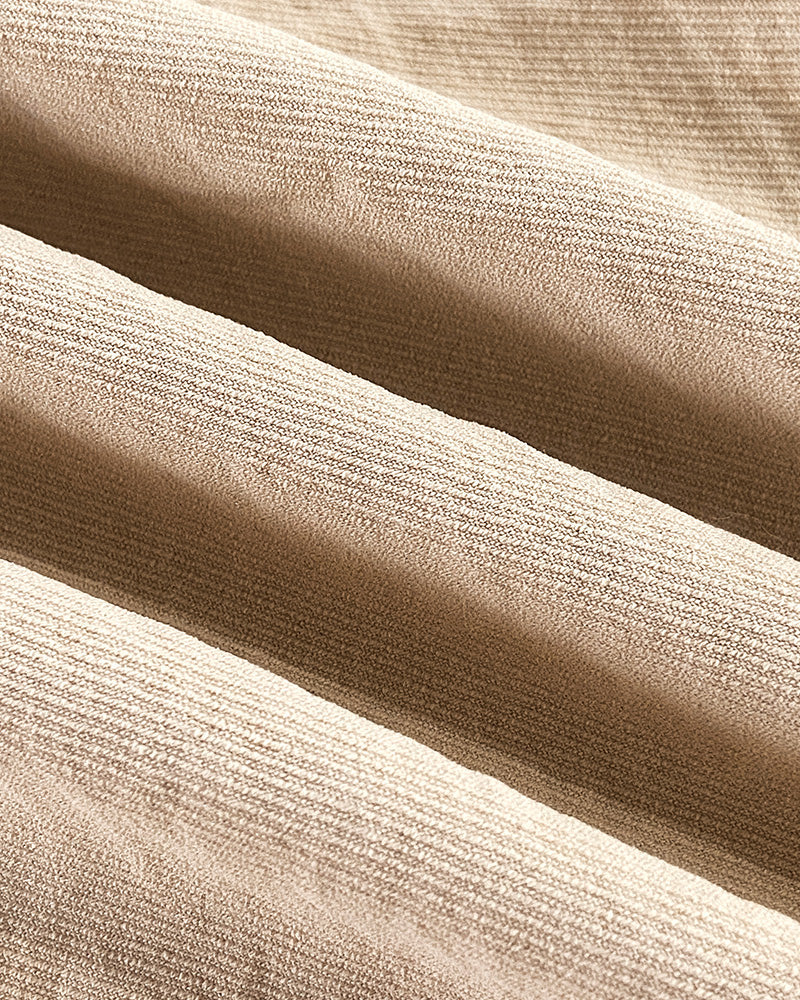 Close-up of beige woven blouse and wide leg pants with subtle sheen and soft texture.