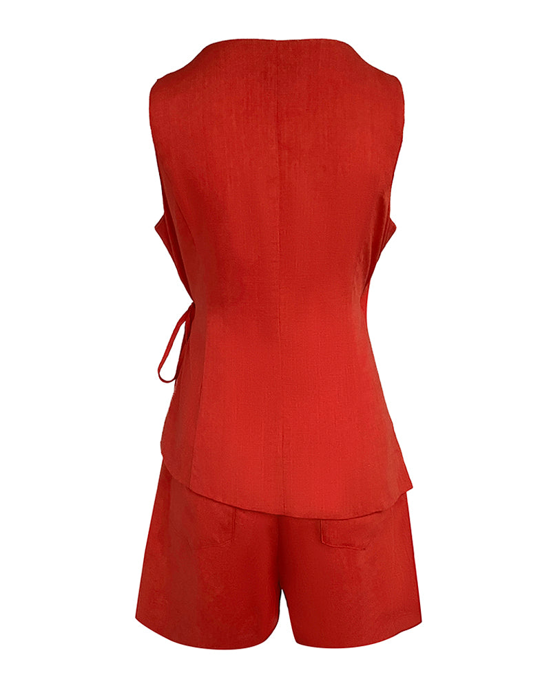 Sleeveless fitted linen wrap top with waist tie and loose pocketed shorts, both textured.