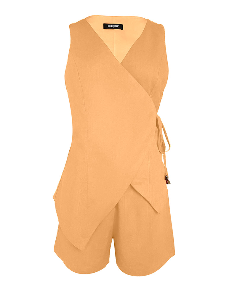 Sleeveless light orange linen wrap top with side tie, V-neck, and matching pocketed shorts.