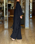 Black high-neck cape with ruffles and matching wide-leg pants from LA FINE FLEUR .