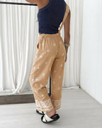 A vintage embroidered tribal suspender jumpsuit with a front bib pocket.