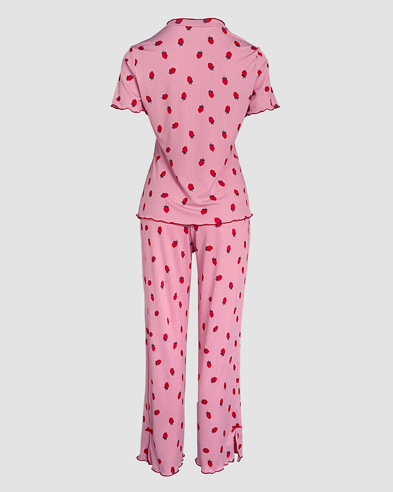 Pink pajama set with playful red strawberries, stand collar tee, short sleeves, and long pants.