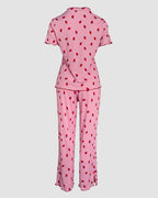 Pink pajama set with playful red strawberries, stand collar tee, short sleeves, and long pants.