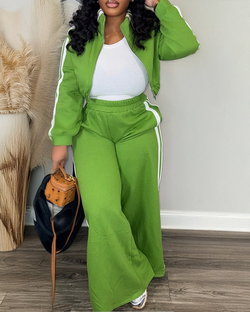 Bright green zip-up crop coat and wide-leg pants with white stripes, paired with a white top.