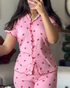 Pink strawberry print pajama set with red trim, featuring a stand collar tee and pants.