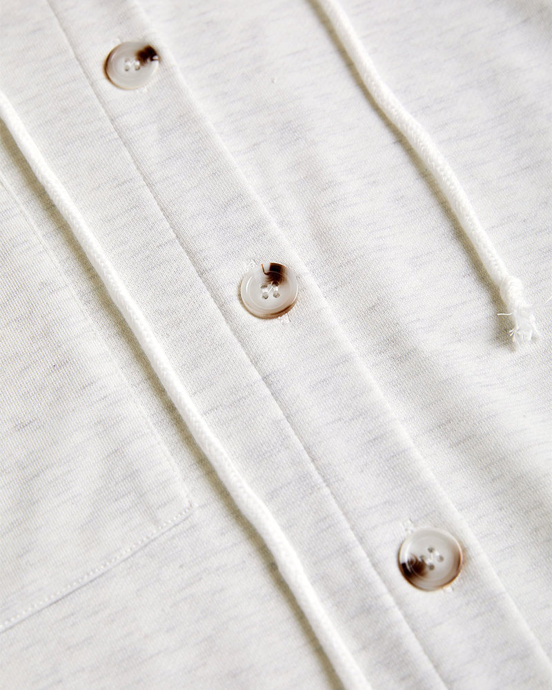 Light grey ribbed long sleeve hoodie coat with cream buttons, drawstring, asymmetrical hem.