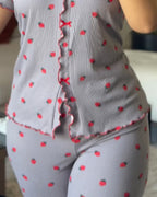 Gray pajama set with red strawberries, ruffled edges, red bows, and a stand collar tee.
