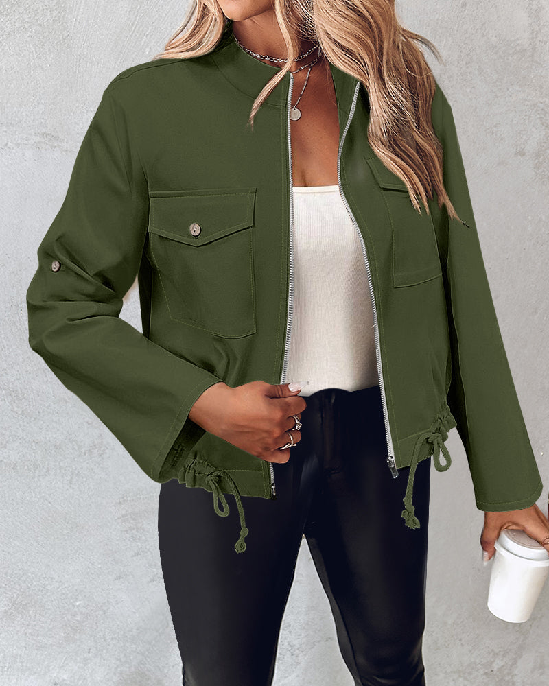 Green roll tab sleeve zip jacket with drawstring hem, worn over a white top and black pants.