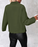 Olive green LA FINE FLEUR roll tab sleeve zip jacket with drawstring hem and black leather pants.