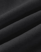 Close-up of black textured fabric with soft folds, from a V-neck vest crop top.
