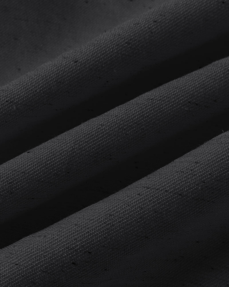 Close-up of black textured fabric with soft folds, from a V-neck vest crop top.