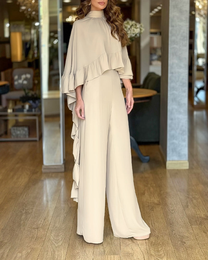 A beige high neck cape with layered ruffles paired with wide-leg pants ensemble.