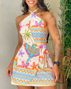 A tropical print halter backless romper with tie-back and wrap skorts, butterfly patterns.