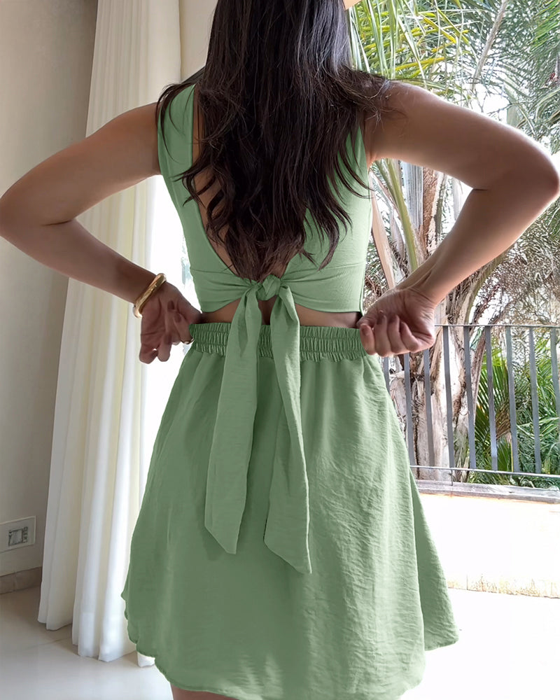 Square neck thick strap textured romper with tie back, skort design, back cutout, bow.