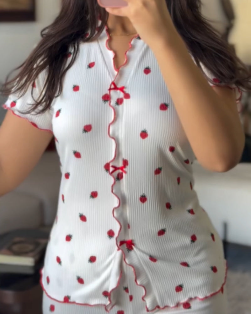 White strawberry print pajama set with red frilled edges and small red bows.