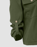 Olive green zip jacket with roll tab sleeves, drawstring hem, pockets, and structured tailoring.