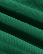 Close-up of green textured blouse and wide leg pants with ridges and diagonal lines.