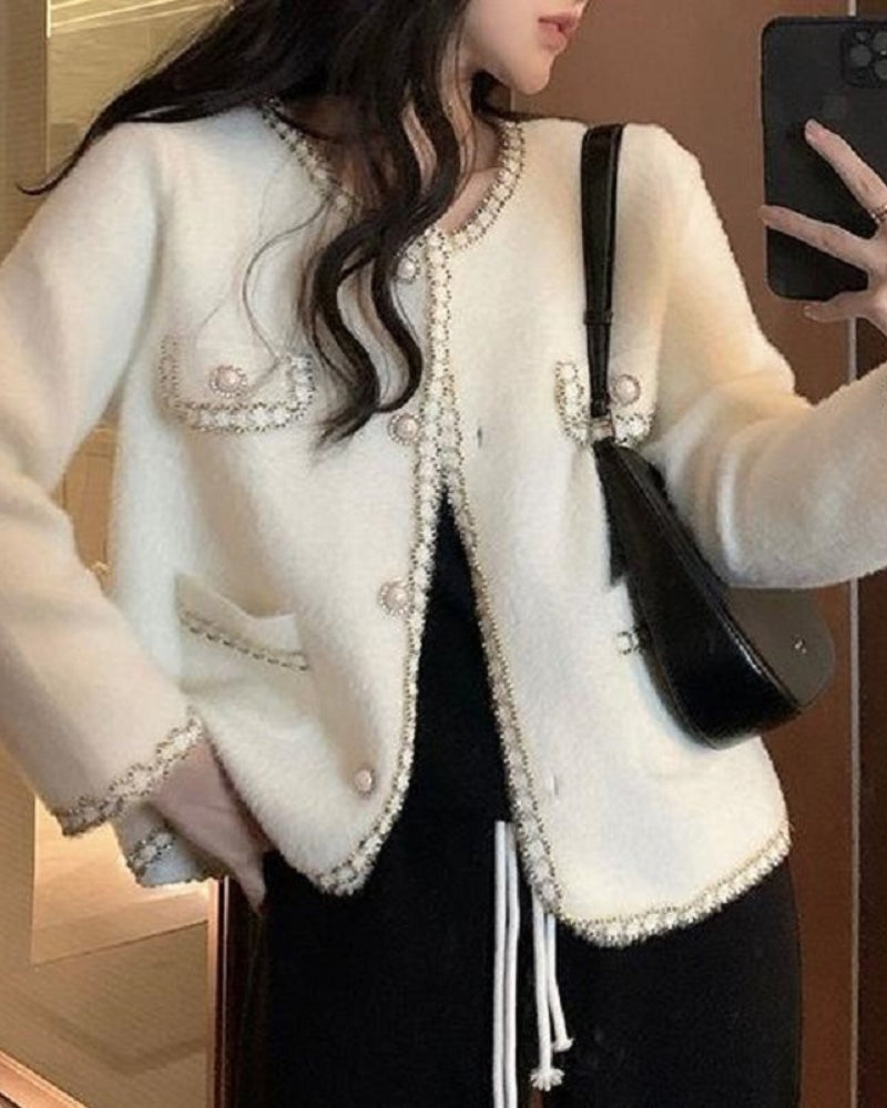 LA FINE FLEUR  Pearl Button Fluffy Cardigan with contrast trim, flap pockets, over black top and pants.