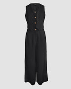 A black sleeveless V-neck vest crop top with wide-leg pants and three brown buttons.