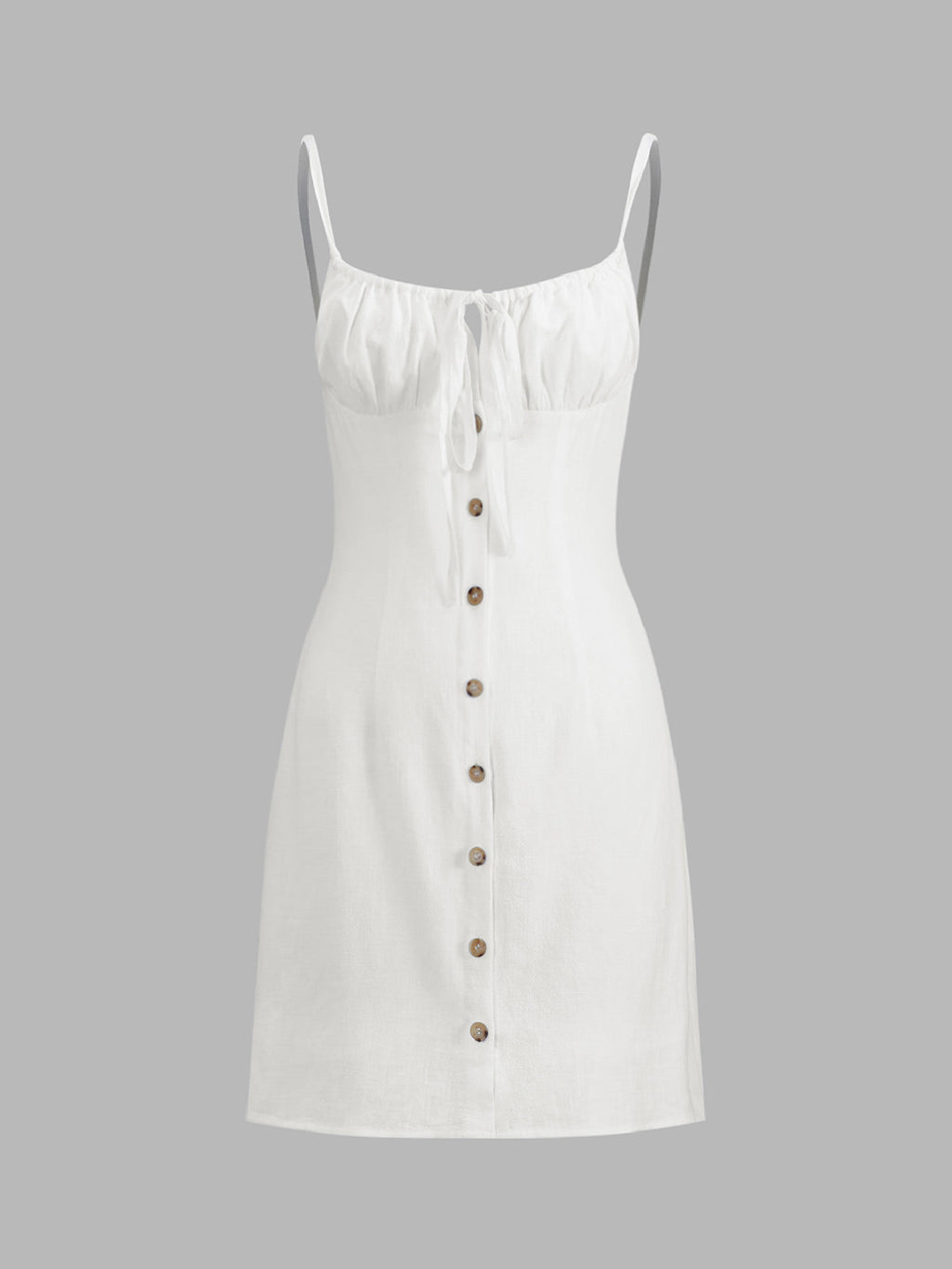 White sleeveless linen mini dress with thin straps, gathered bust tie, and brown buttons.