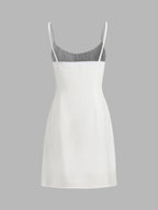A sleeveless white linen mini dress with thin straps and a fitted, knee-length silhouette.