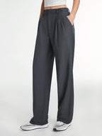 Dark gray tailored straight-leg dress pants, light cropped top, and white sneakers.