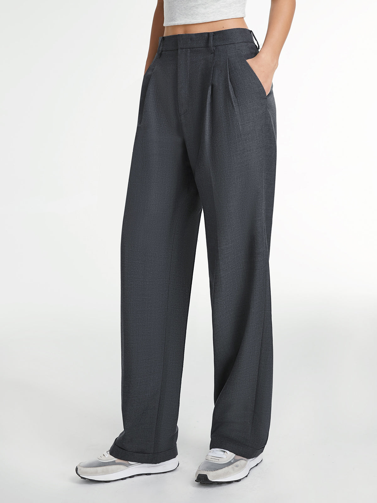 Dark gray tailored straight-leg dress pants, light cropped top, and white sneakers.