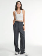 Light gray sleeveless crop top and dark gray straight-leg tailored dress pants with white sneakers.