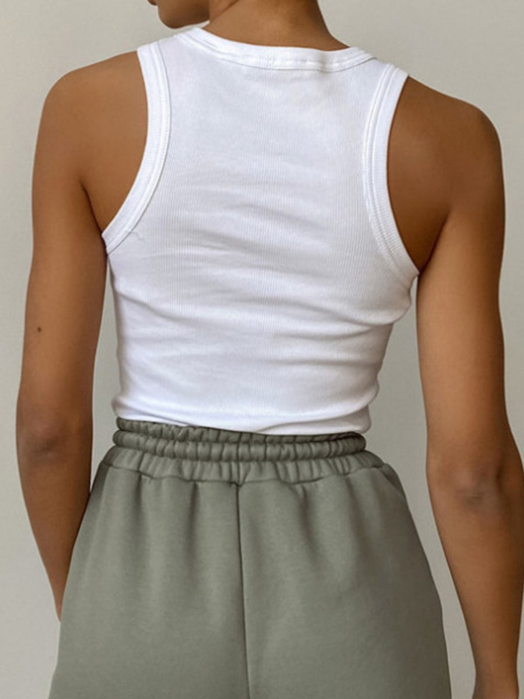 White Ellis sleeveless crop top paired with sage green elastic-waist sweat shorts.