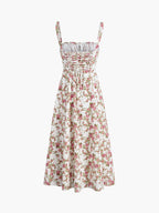A midi dress with thin straps, ruched bodice, flared skirt, pink and green floral print.