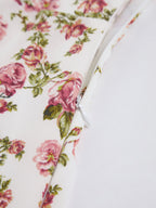 White midi dress with pink floral print, featuring a partially unzipped white zipper and visible seams.