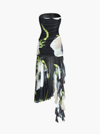A strapless black midi dress with white floral prints, ruched bodice, and asymmetrical mesh skirt.