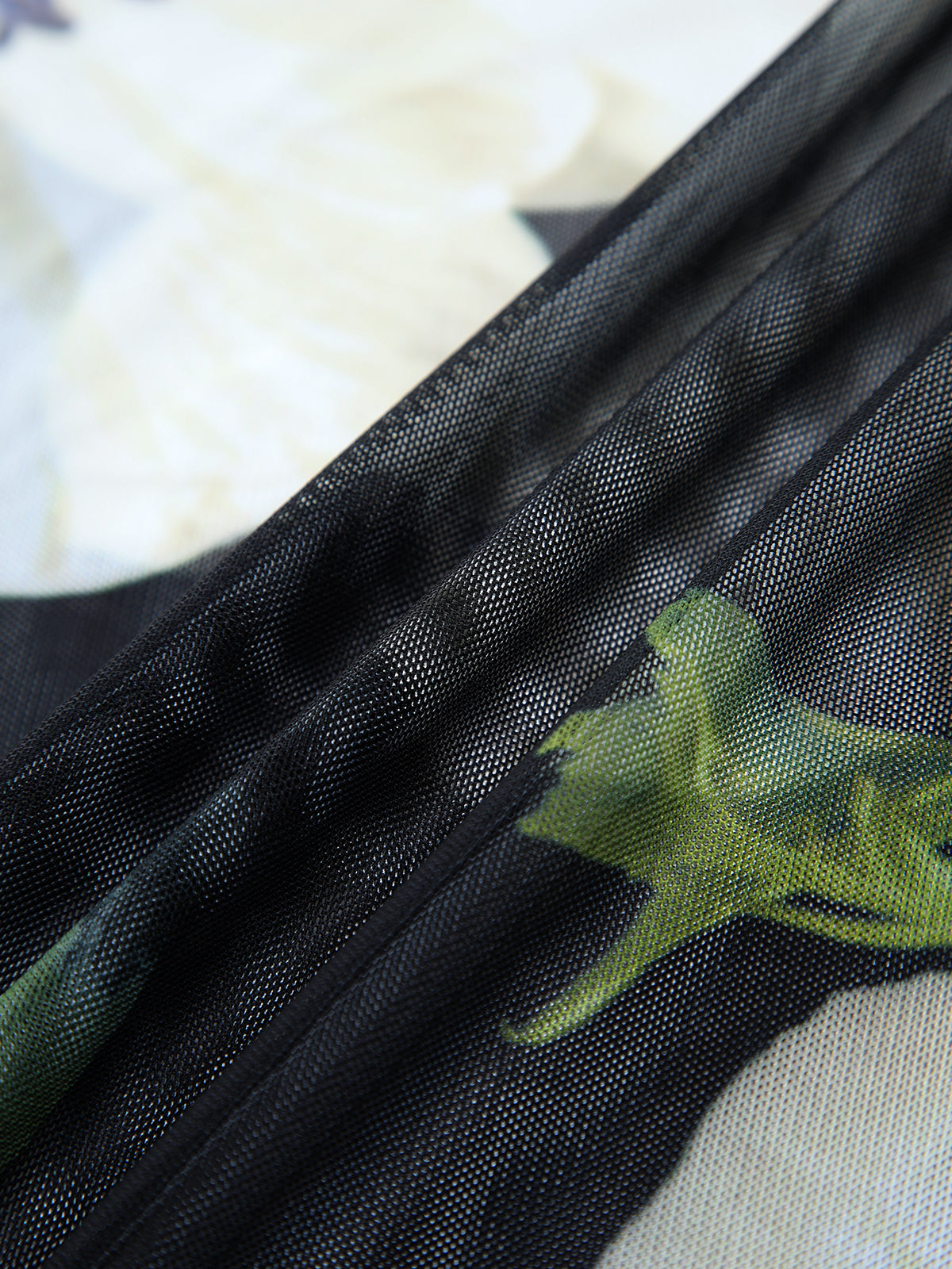 Pleated tube midi dress in black sheer mesh with green and white floral pattern.