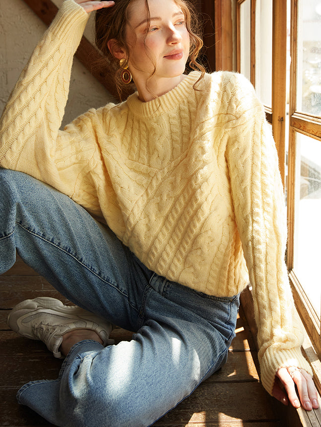 An oversized knit sweater in a limoncello shade paired with light wash denim jeans.