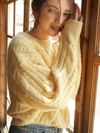 An oversized yellow knit sweater paired with classic jeans, showcasing a casual, cozy style.