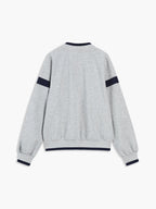 Light grey oversized sweatshirt with navy sleeve stripes and ribbed navy-trimmed cuffs, collar, waistband.