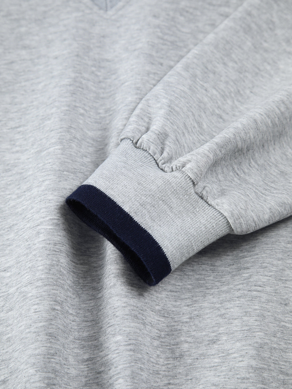 Light gray oversized sweatshirt with long jersey sleeves, navy trim, and elastic cuffs.