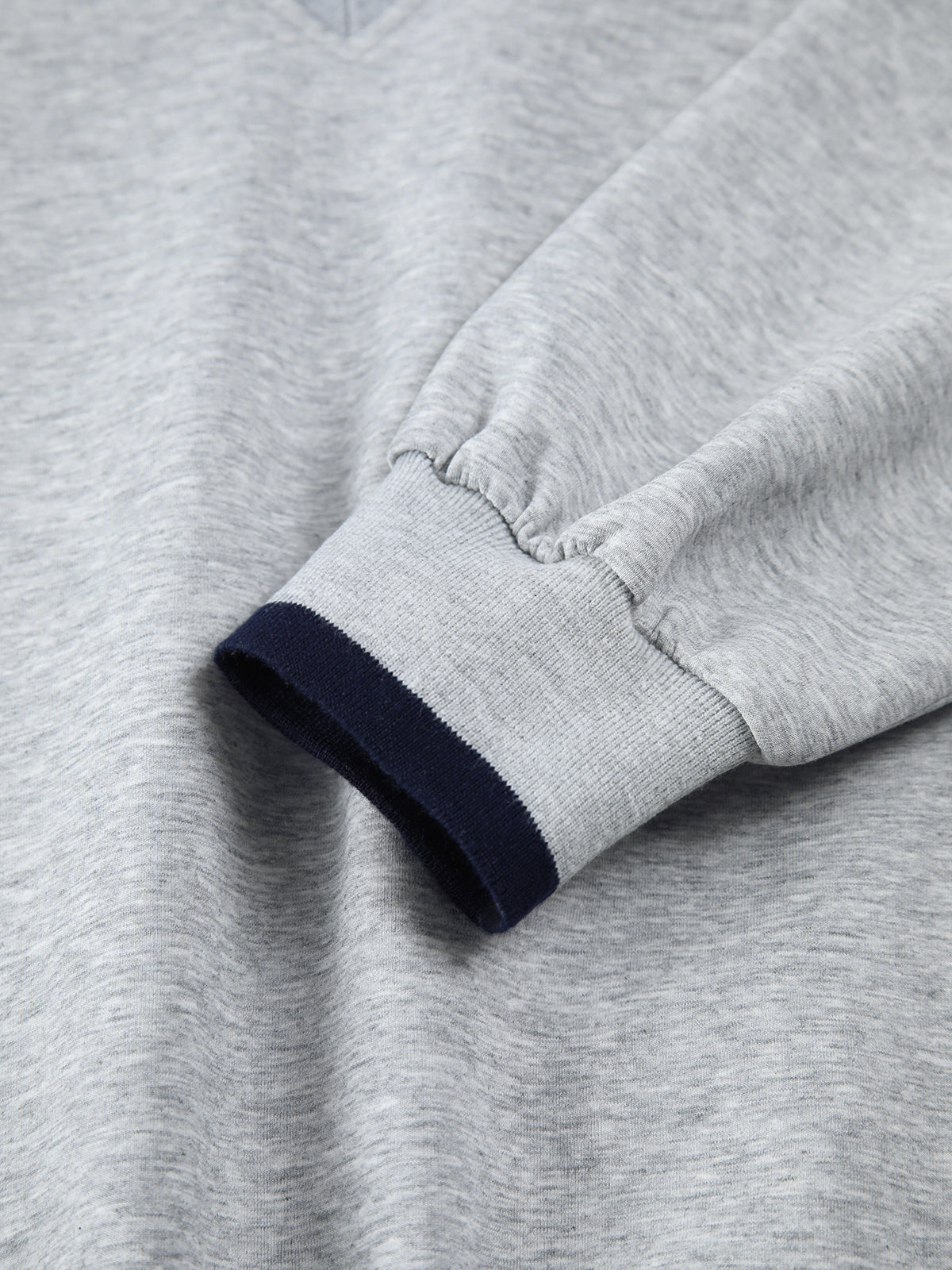 Light gray oversized sweatshirt with long jersey sleeves, navy trim, and elastic cuffs.