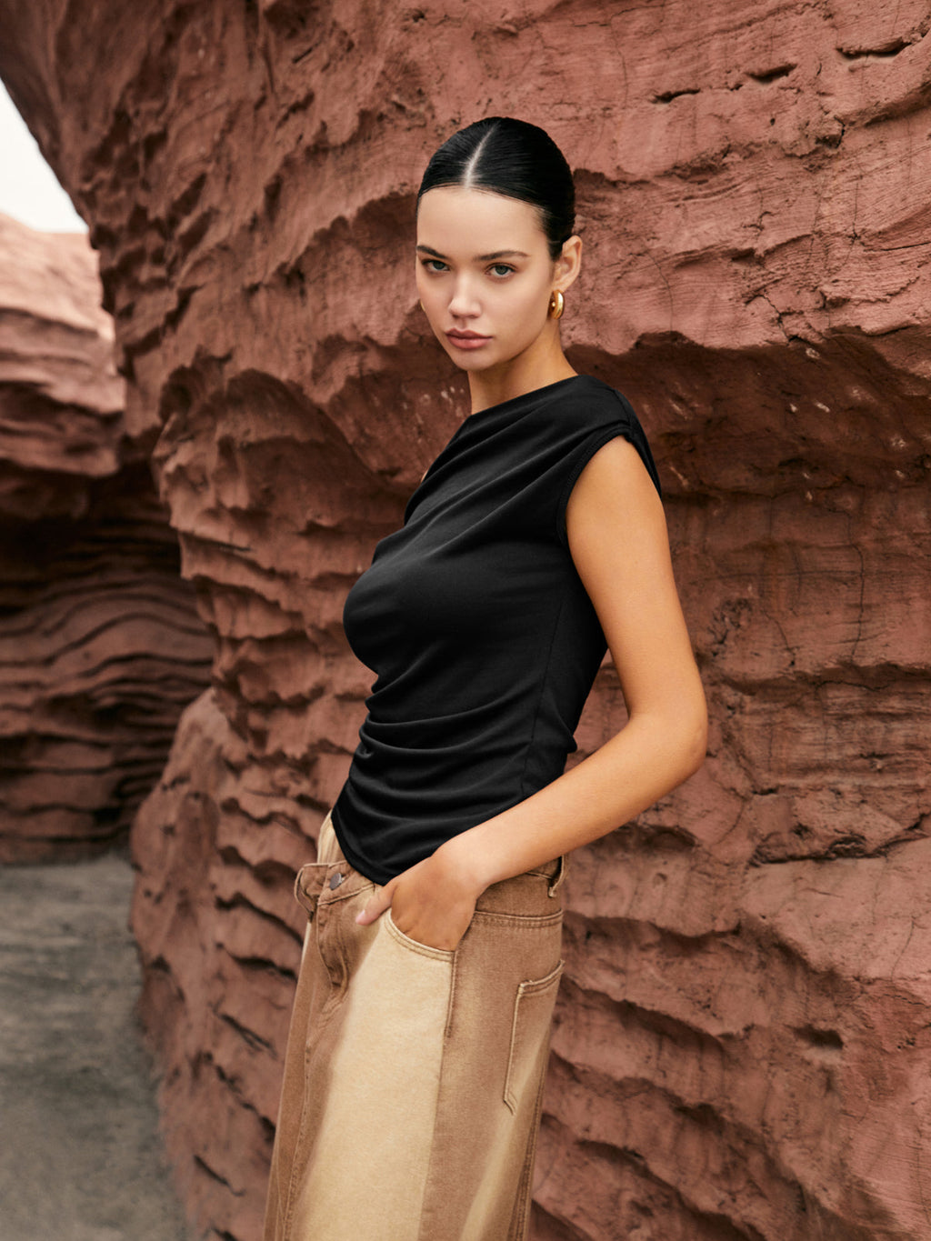 The LA FINE FLEUR Unique One-Shoulder Top with Elegant Side Knot and beige pants.