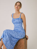 Light blue midi dress with dark blue floral print, ruched bodice, and tie straps.