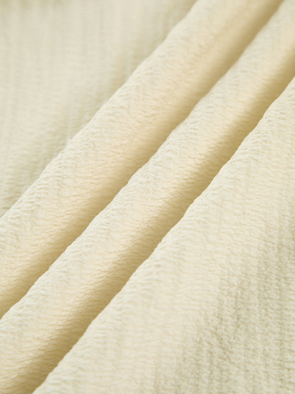 Light beige wavy crinkled-texture fabric dress with split midi hem and criss cross back.